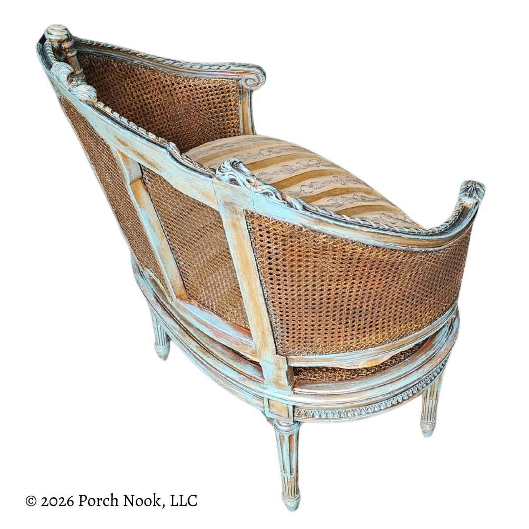 Wicker bench with striped cushion on a white background