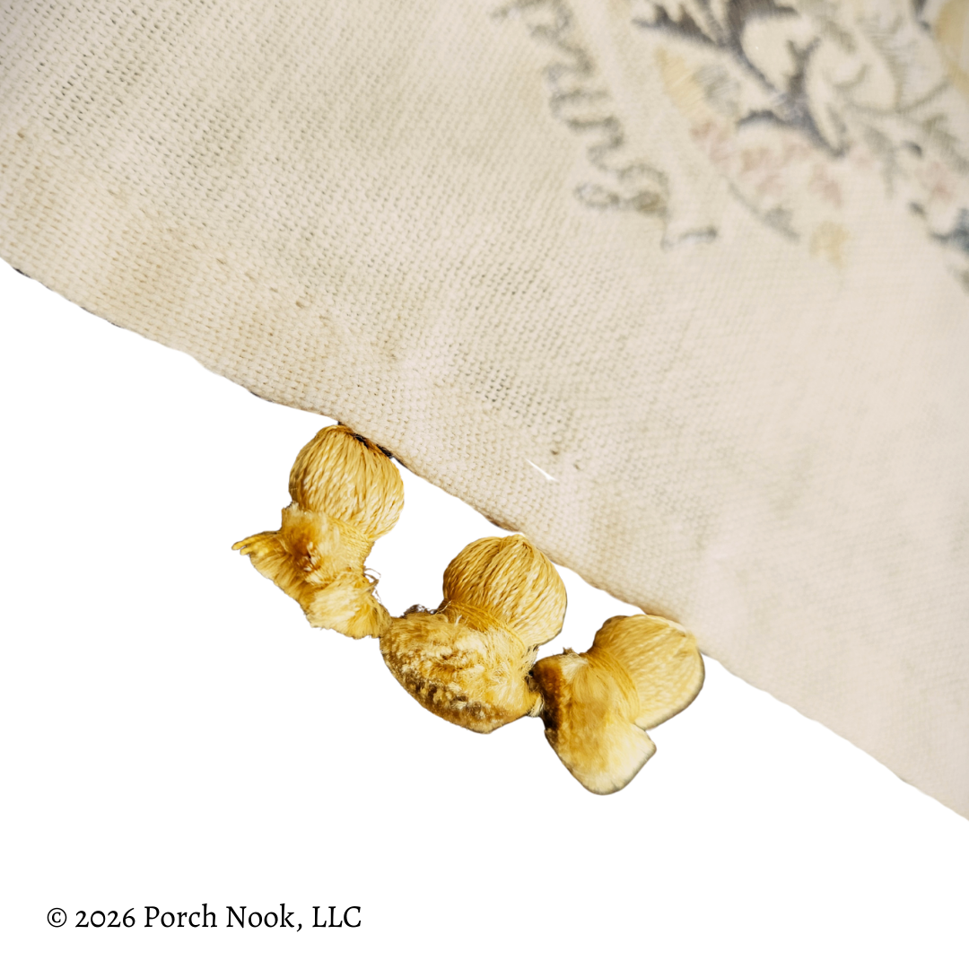 Decorative yellow tassels with floral trim on a white background