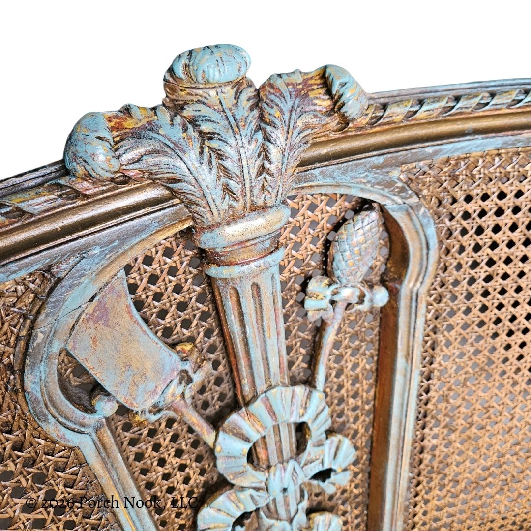 Decorative element of a vintage chair with intricate detailing and wicker back.