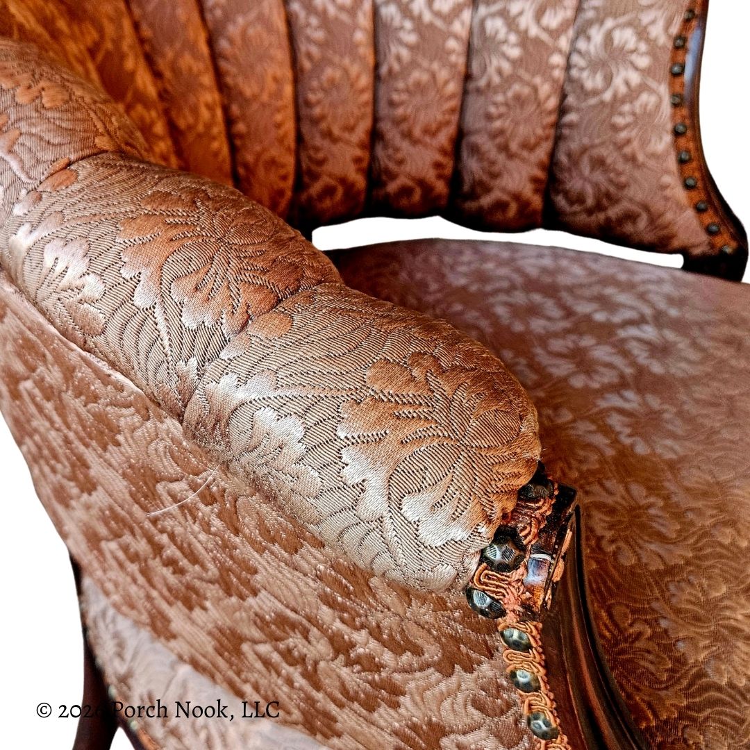 Close-up of a brown embroidered chair with intricate patterns and decorative elements.