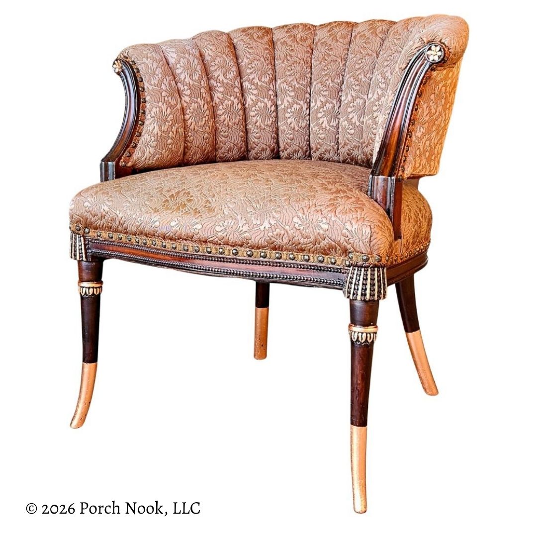 Decorative armchair with floral pattern and wooden legs with copper accents on a white background