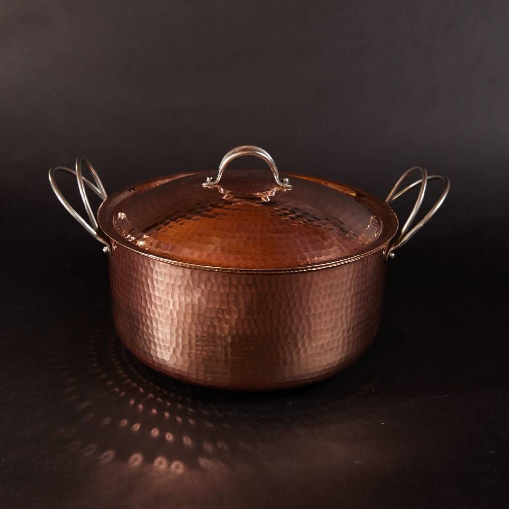 Copper pot with lid on a dark background