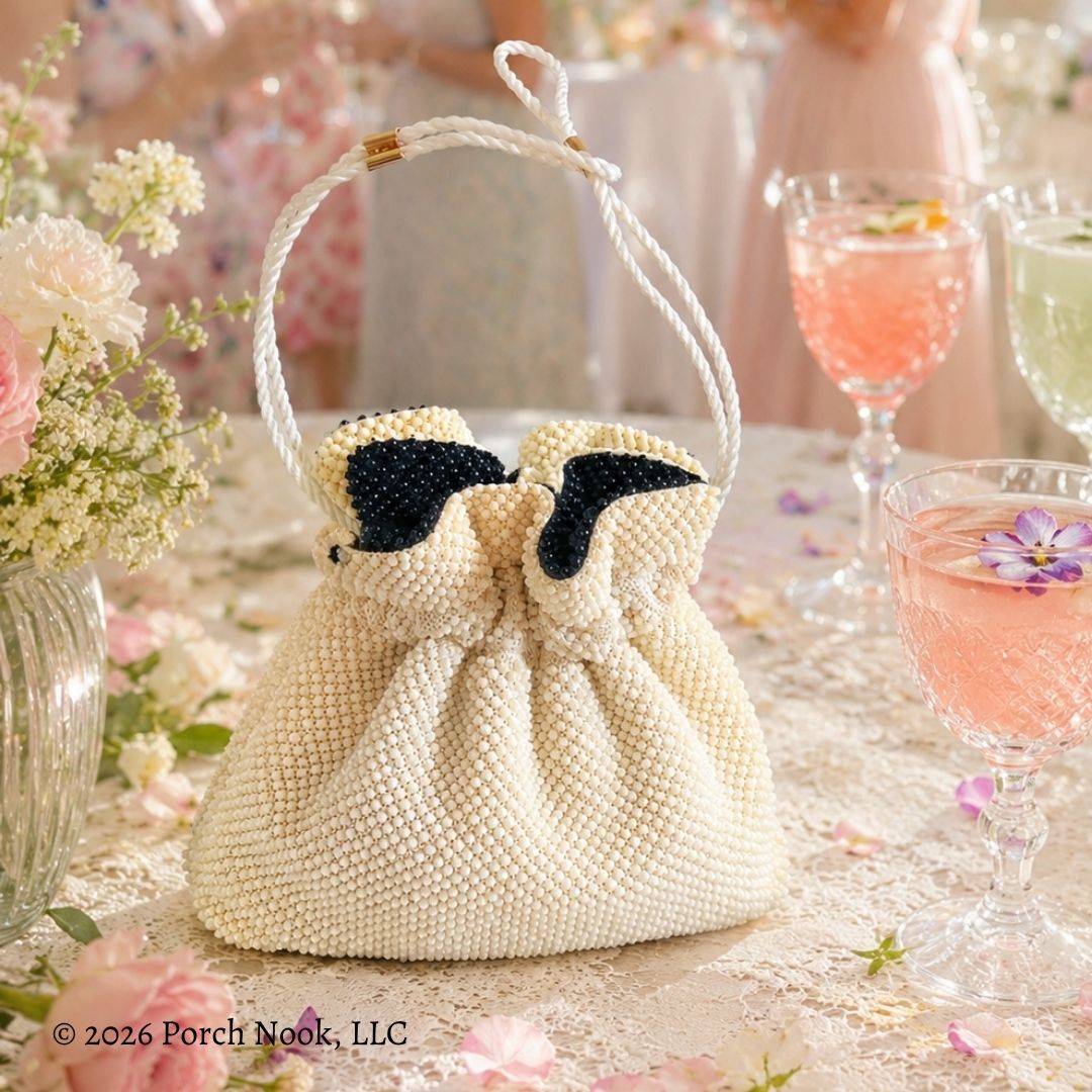 Vintage Reversible Black & Ivory Micro Beaded Drawstring Evening Bag on a table with flowers and glasses