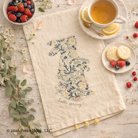 Tea towel with 'hello spring!' text on a table with tea, berries, and cookies.