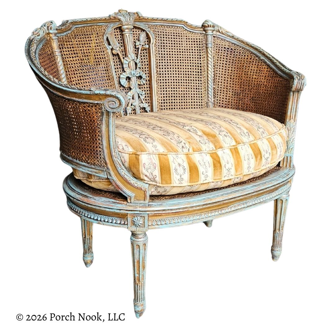 Decorative armchair with caned backrest and striped cushion on a white background