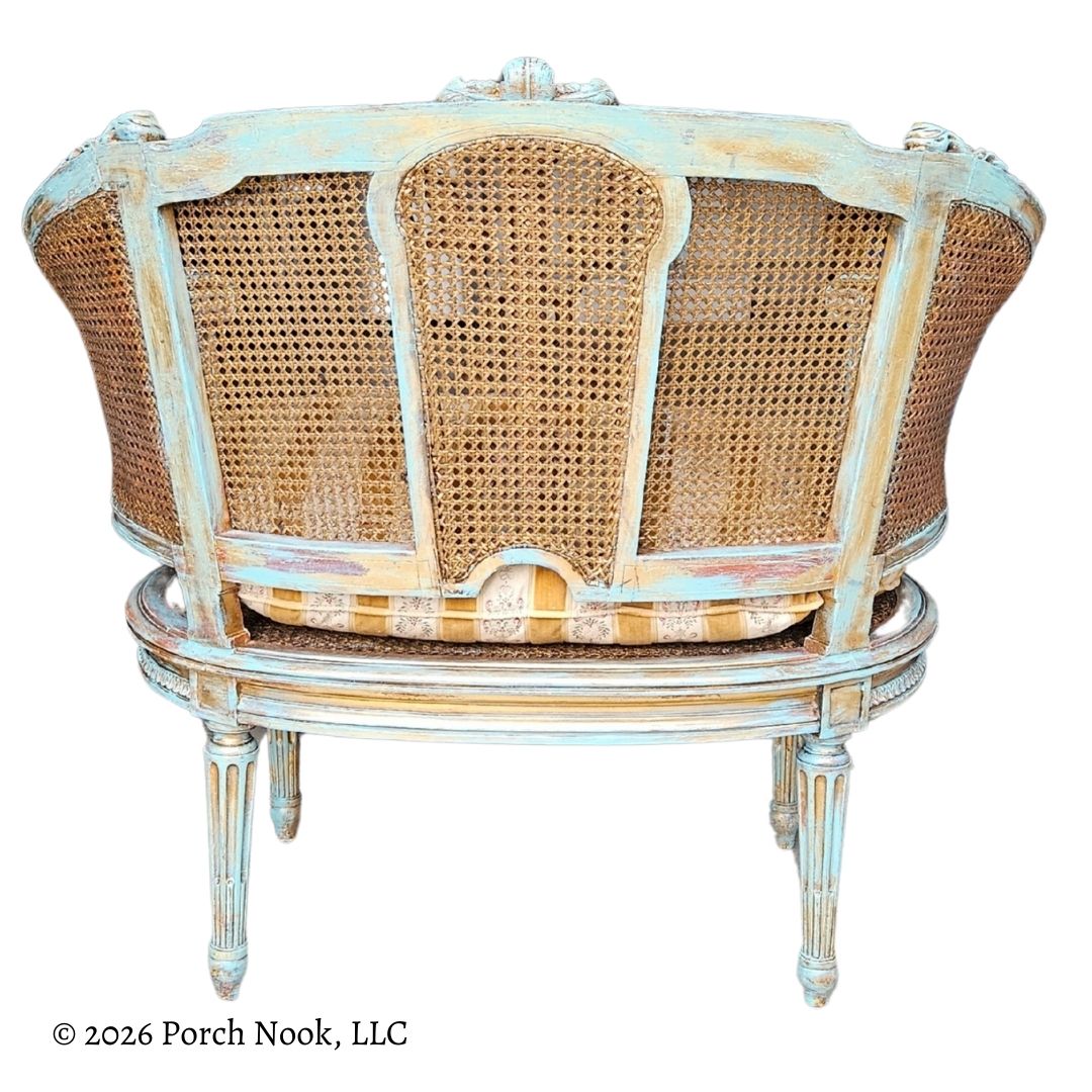 Painted cane back chair with decorative frame on a white background