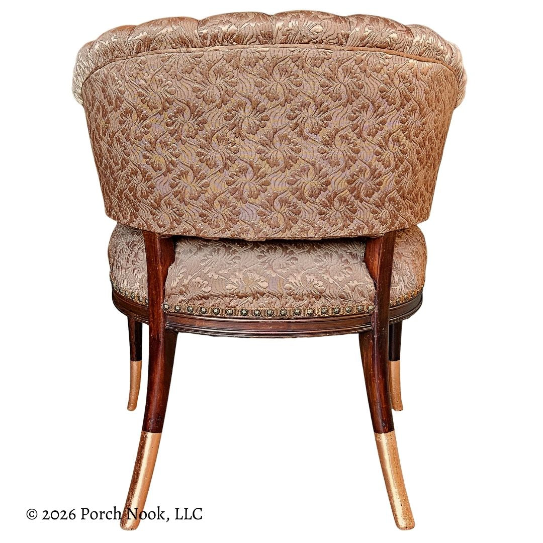 Decorative chair with floral pattern and wooden legs accented with metallic copper gilding on a white background