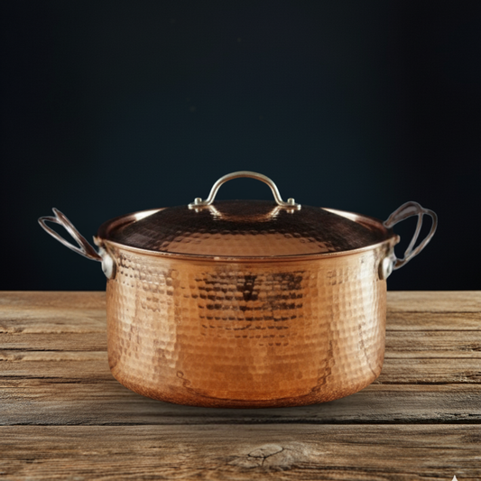Copper Dutch Oven pot with lid on a wooden surface against a dark background