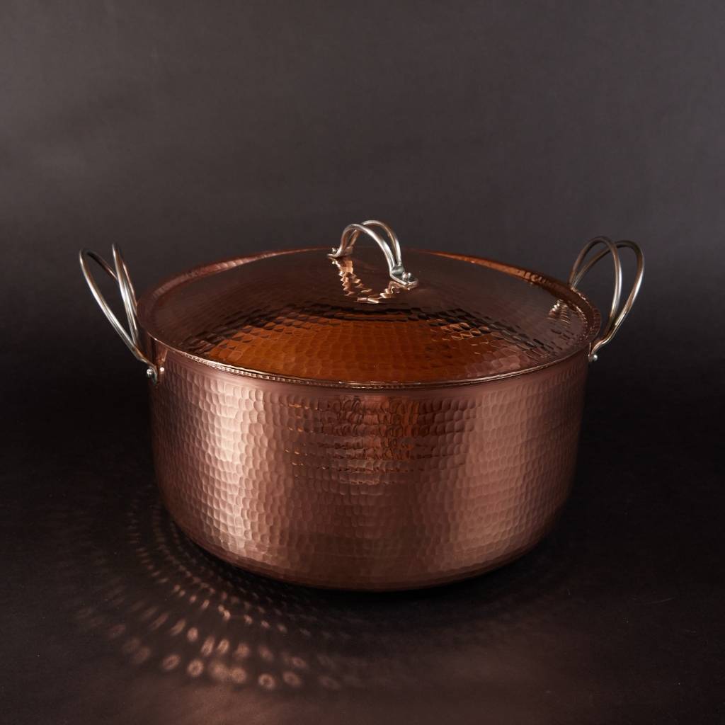 Copper pot with lid on a dark background