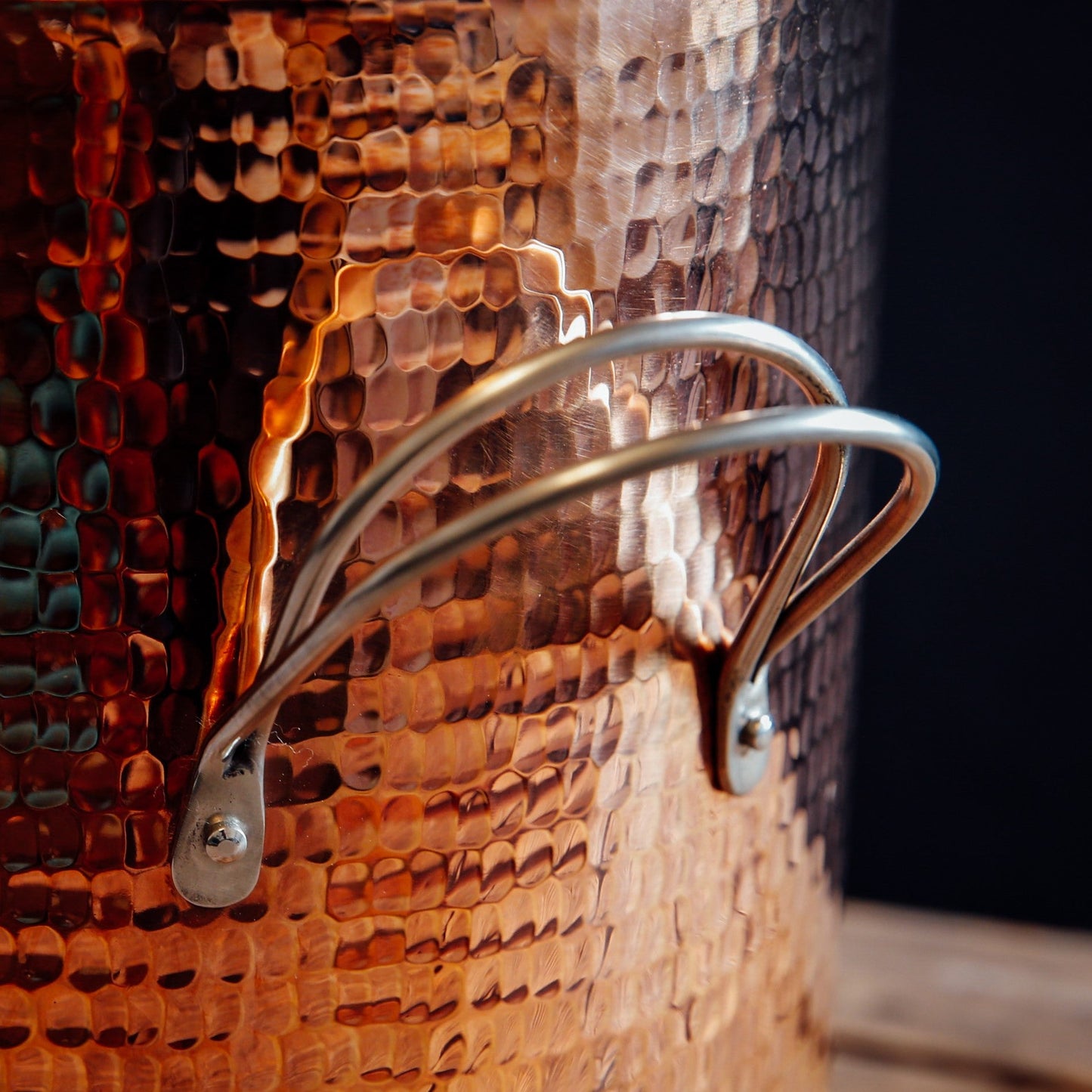 Close-up of a textured copper stock pot with a metal handle.