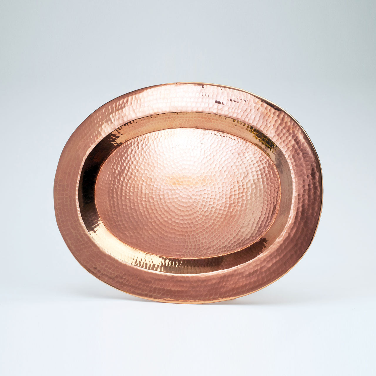Copper plate with a hammered texture on a light gray background