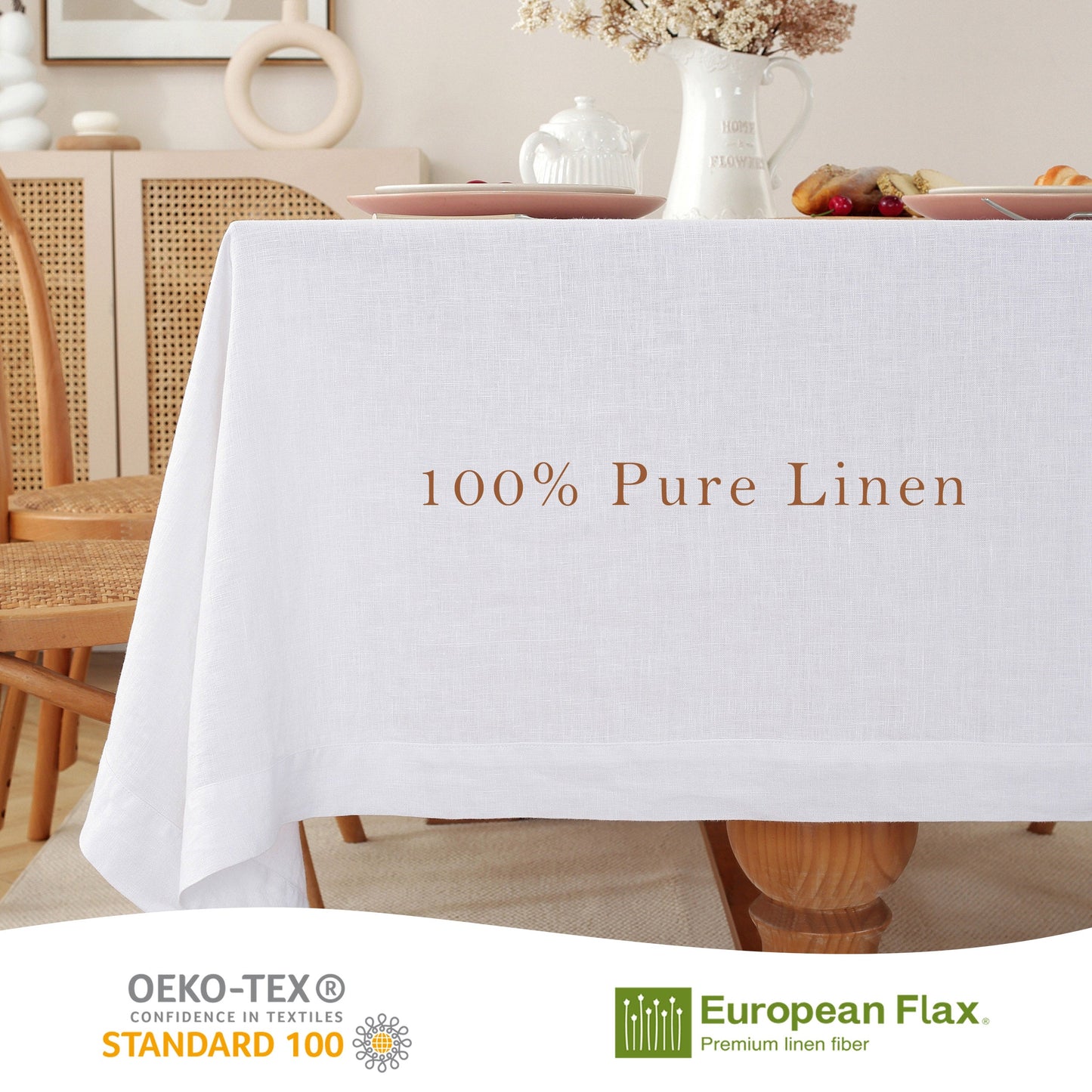 A white linen tablecloth draped over a dining table in a softly styled room, with the text '100% Pure Linen' printed on the front. The scene includes chairs, plates, a vase, and a tabletop setting.